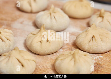 Hausgemachte raw khinkali Knödel auf Holzbrett, Nahaufnahme Stockfoto