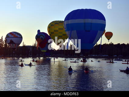 Canberra, Australien - 11. März 2018. Kajakfahrer beobachten große bunte Heißluftballons am Lake Burley Griffin, als Teil des Ballons spektakuläre Fest Stockfoto