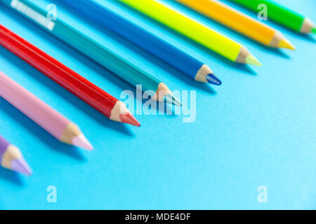 Verschiedene Farbstifte in einer Reihe auf einem Papier organisiert Stockfoto