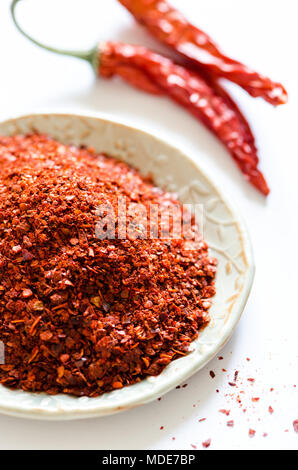 Paprikapulver mit roten Chilischoten auf weißem Hintergrund Stockfoto