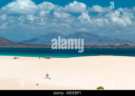 FUERTEVENTURA - 29. SEPTEMBER: ein junges Paar in den Sanddünen von Corralejo am Meer auf Fuerteventura, Spanien mit Lanzarote im Hintergrund auf Septem Stockfoto