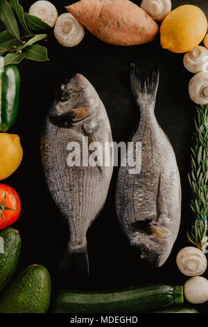 Von oben zwei dorado Fisch und Rahmen aus Gemüse. Stockfoto