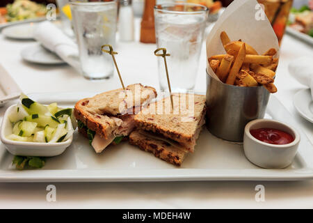 Die Türkei Club Sandwich mit Pommes Frites mit Freunden Stockfoto