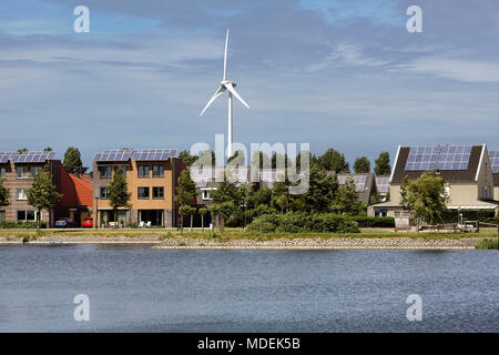 Häuser mit Solarzellen mit einer Windkraftanlage in Stad van de Zon (Stadt der Sonne), eine nachhaltige Vorort von Heerhugowaard, Niederlande. Stockfoto