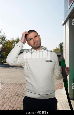Der Mann dachte an der Tankstelle Stockfoto