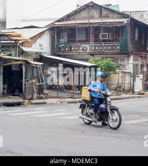 Eine vietnamesische Kurier Motorrad fahren in Ho Chi Minh City, Vietnam. Stockfoto