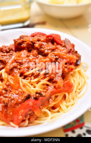 Eine Platte mit gekochten Spaghetti Bolognese gemacht mit Angel Hair Pasta auf dem Esstisch. Stockfoto