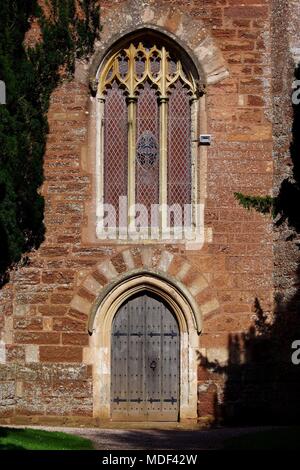 Turm der St. Clement's Church, Gotisches Fenster und Tür aus Eichenholz. Powderham, Exeter, Devon, Großbritannien. April, 2018. Stockfoto