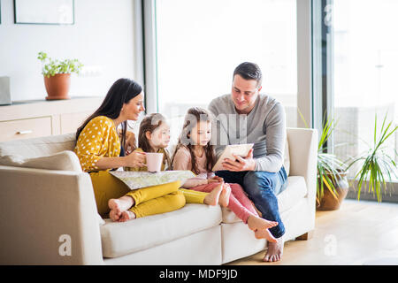 Junge Familie mit zwei Kindern und Tablet Vorbereitung für den Urlaub. Stockfoto