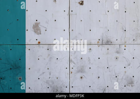 Holz Fliesen mit Löchern und Rostige Schrauben. Abgeplatzte Farbe verschmutzt Holz Hintergrund Oberfläche. Stockfoto