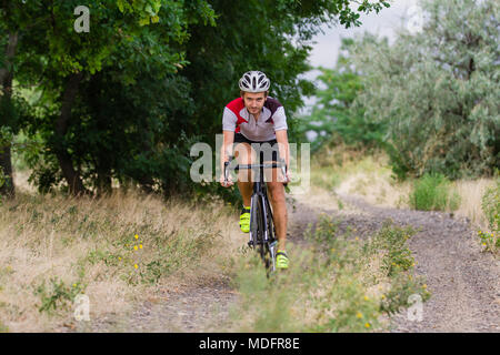 Radprofi training offroad Reiten in Felder, Fahrrad Fahrer allein im Freien Stockfoto