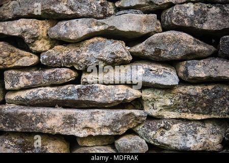 Hintergrund der alten Steine in der Wand. Die Textur der Stein bedeckt mit Moos Stockfoto