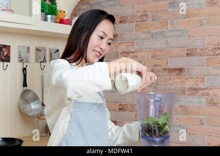 Asiatische Frau, oganic Food mit Blender in der Küche Stockfoto
