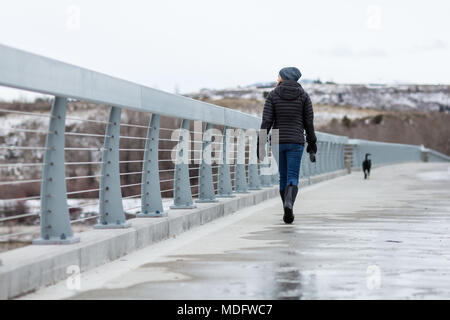 Frau, die mit ihrem Hund über eine Brücke geht, Wyoming, USA Stockfoto