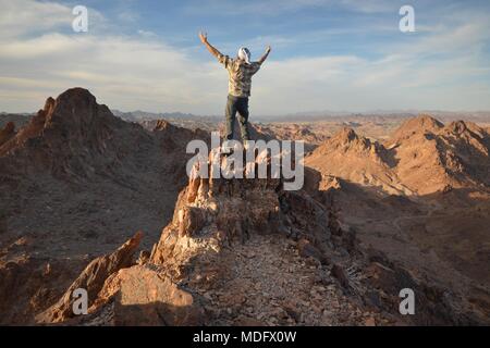 Mann auf dem Berggipfel mit ausgestreckten Armen, Indian Pass Wilderness, Kalifornien, USA Stockfoto