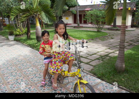 Kinder mit dem Fahrrad in Wat Chanthaboury buddhistischer Tempel. Vientiane, Laos, 2015. Stockfoto