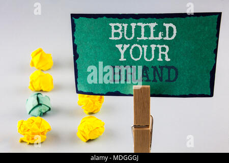 Handschrift Text schreiben bauen Ihre Marke. Konzept, d. h. Erstellen Sie Ihr eigenes Logo slogan Modell Werbung E Marketing geschrieben Haftnotiz Paper Holding Stockfoto