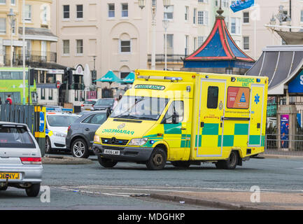 Krankenwagen des britischen Gesundheitsdienstes im geschäftigen Verkehr an einem Kreisverkehr, auf Abruf mit blinkenden Ampeln in Brighton, East Sussex, Großbritannien. Mercedes Sprinter 416 CDI von 2006. Stockfoto