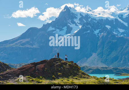 Drei Touristen genießen den Blick auf die Torres del Paine massiv, während auf einem Trekking im Nationalpark Torres del Paine, Patagonien, Chile. Stockfoto