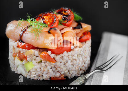 Räucherlachs auf Dinkel mit Gemüse, dekoriert mit frischem Dill. Stockfoto