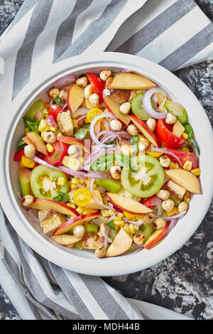 Vegan Salat mit Nektarinen Pfirsiche, verschiedene Arten von Tomaten, Paprika, Mais, Zwiebeln, Macadamianüsse, Basilikum und Paniermehl. Ansicht von oben geschossen. Stockfoto