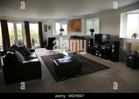 Modernes Wohnzimmer mit Flachbildschirm-Fernseher, Lautsprecher und Glas Couchtisch Cheltenham Gloucestershire England Stockfoto