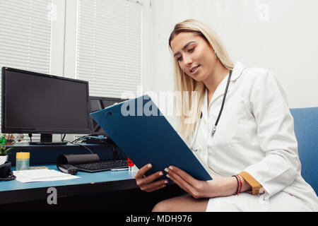 Arzt im Büro Kontrolle unterlagen und medizinischen Daten des Patienten. Gesundheitswesen und Medizin Konzept Stockfoto