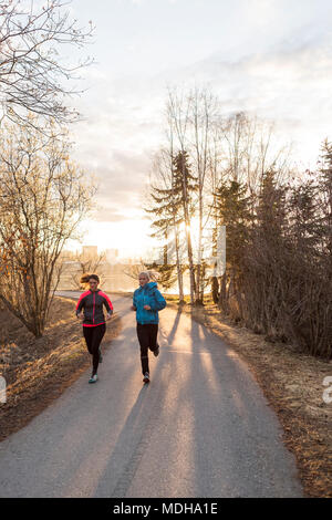 Zwei junge Frauen, die auf einem Trail bei Sonnenaufgang, Anchorage, Alaska, Vereinigte Staaten von Amerika Stockfoto