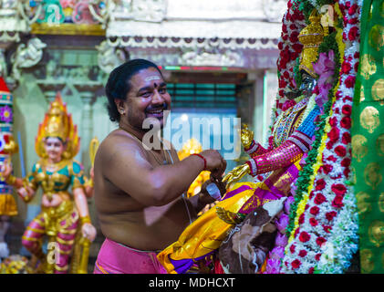 Indischer Mann schmückt Idol im Tempel von Sri Veeramakaliamman in Little India, Singapur Stockfoto