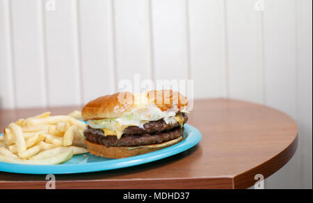 Double Cheeseburger auf eine süße Brötchen mit einer Seite der Pommes frites Stockfoto