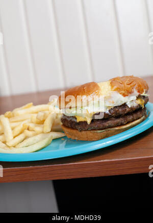 Double Cheeseburger auf eine süße Brötchen mit einer Seite der Pommes frites Stockfoto