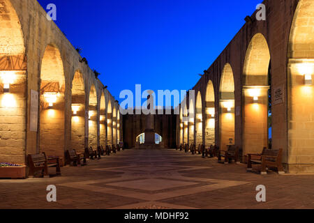 Valletta, Malta, Upper Barrakka Gardens. Beleuchtete steinbögen am Abend, klaren dunklen blauen Himmel. Stockfoto