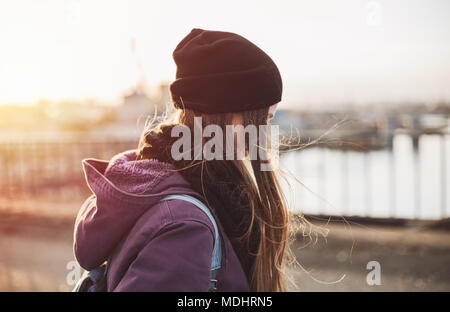 Hipster Mädchen zu Fuß auf die Brücke bei Sonnenuntergang Stockfoto