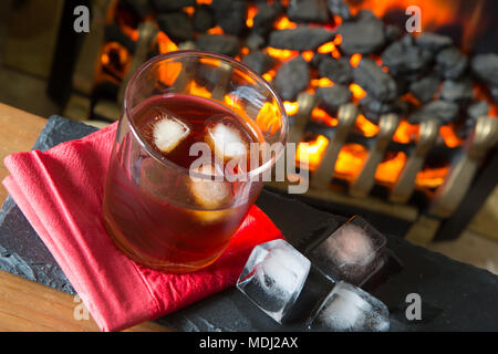 Glas Whisky auf den Felsen mit einem Brand Hintergrund Stockfoto