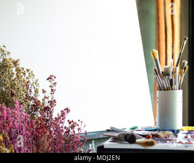 Leere weiße Leinwand auf Holz Staffelei, acylic Farbe in der Palette, Malerei Pinsel, chemische Blume in der Künstler Sudio Stockfoto