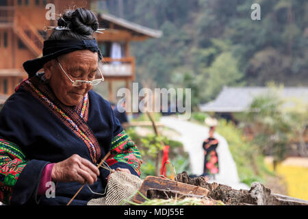 Langde, China - März 27, 2018: Alte Miao Frau Weberei in Langde Miao Dorf, Provinz Guizhou, China Stockfoto