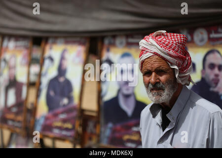 In Gaza. 20 Apr, 2018. Ein palästinensischer Mann steht vor der Plakate, die Palästinenser in israelischen Gefängnissen während der großkundgebung am 20. April 2018. Hunderte von Palästinensern auf Freitag verschoben in Richtung der östlichen Gazastreifen Gebiet nahe der Grenze zu Israel für die vierten Freitag Kundgebung gegen Israelis. Credit: Yasser Qudih/Xinhua/Alamy leben Nachrichten Stockfoto