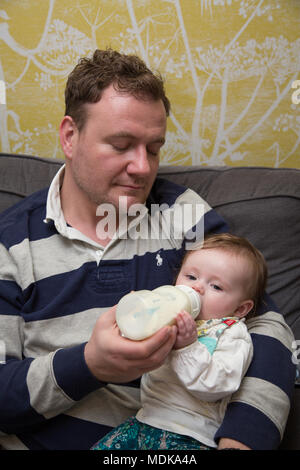 Erschöpft Vati das Füttern mit der Flasche baby Stockfoto