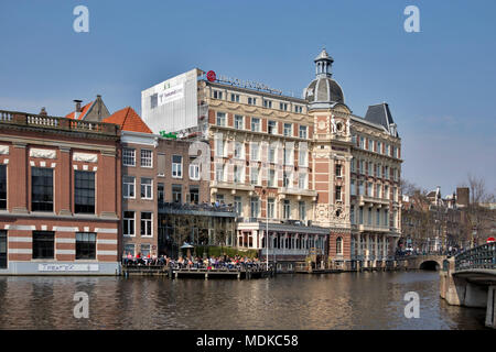 Amsterdam, Niederlande - 14 April 2018 Canal Dock Cafe und NH Doelen Hotel anzeigen. Niederlande, Stockfoto