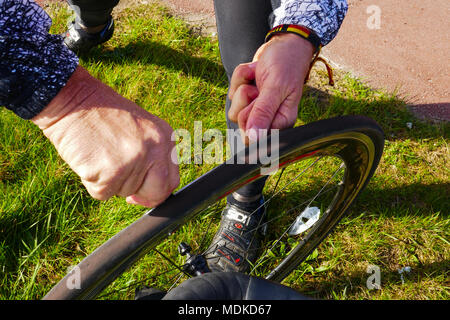 Reparatur einer Reifenpanne ein Fahrrad auf der Straße in Holland Stockfoto