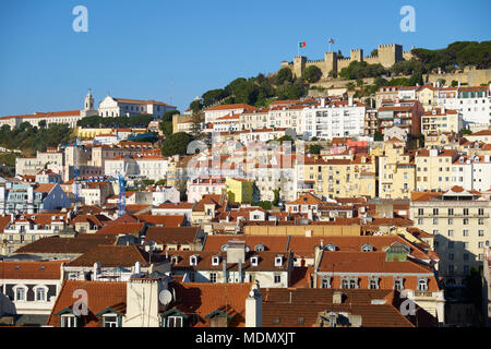 Die Wohnhäuser von Alfama mit Saint George Schloss auf dem Hügel auf dem Hintergrund von der Aussichtsplattform des Aufzug Santa Justa gesehen. Stockfoto