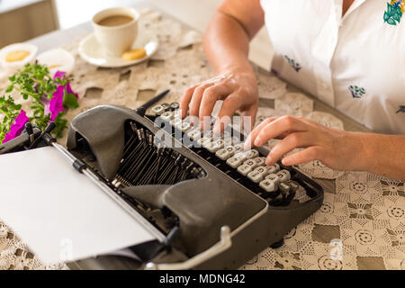 Schreiben Konzept. Thema Hände schreiben auf retro Schreibmaschine auf Spitze Tischplatte platziert. Stockfoto
