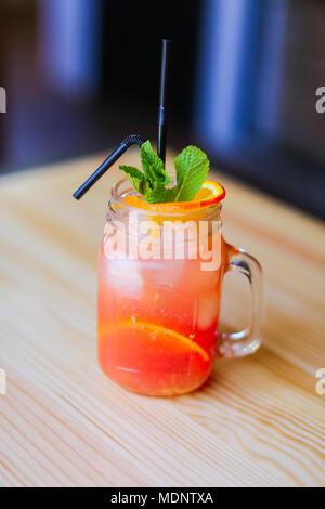 Holztisch mit Glas Orangensaft im gemütlichen Cafe. Stockfoto