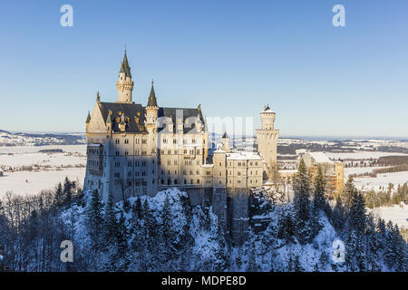 Blick auf das Schloss Neuschwanstein von der Queen Mary's Bridge umgeben von Bäumen und Schnee Stockfoto