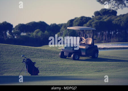 Golfbag mit Club und Ball vorne am wunderschönen Sonnenaufgang auf Kurs Stockfoto
