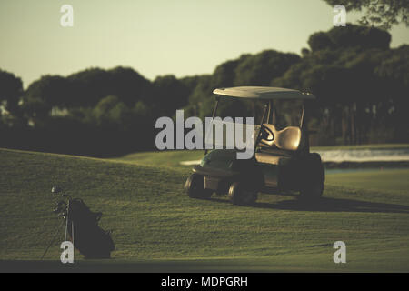 Golfbag mit Club und Ball vorne am wunderschönen Sonnenaufgang auf Kurs Stockfoto