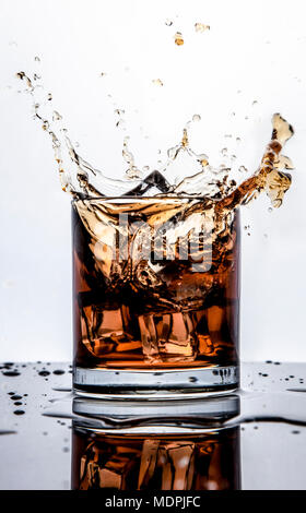 Splash Whisky mit Eis isoliert auf weißem Stockfoto