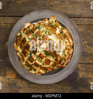 Ziehen neben Brot mit Käse und Knoblauch Butter und Kräutern gefüllt Stockfoto