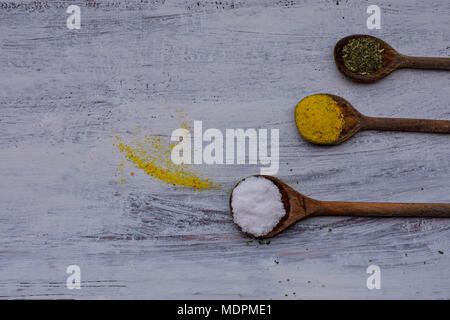 Bunten Gewürzen in Löffel auf weißem Hintergrund Holz, Top View/Küche - Essen Hintergrund Stockfoto