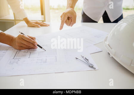 Ingenieure eine Blaupause diskutieren, während Prüfen von Informationen auf einem Tablet Computer in einem Büro. Stockfoto